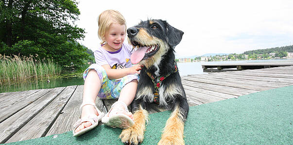 Kind mit Hund am See