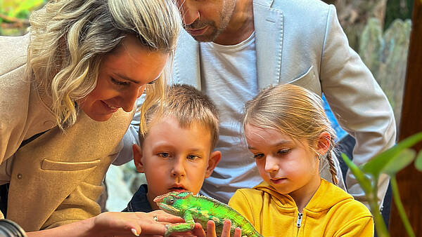 Familie im Reptilienzoo Happ mit einem Chamäleon