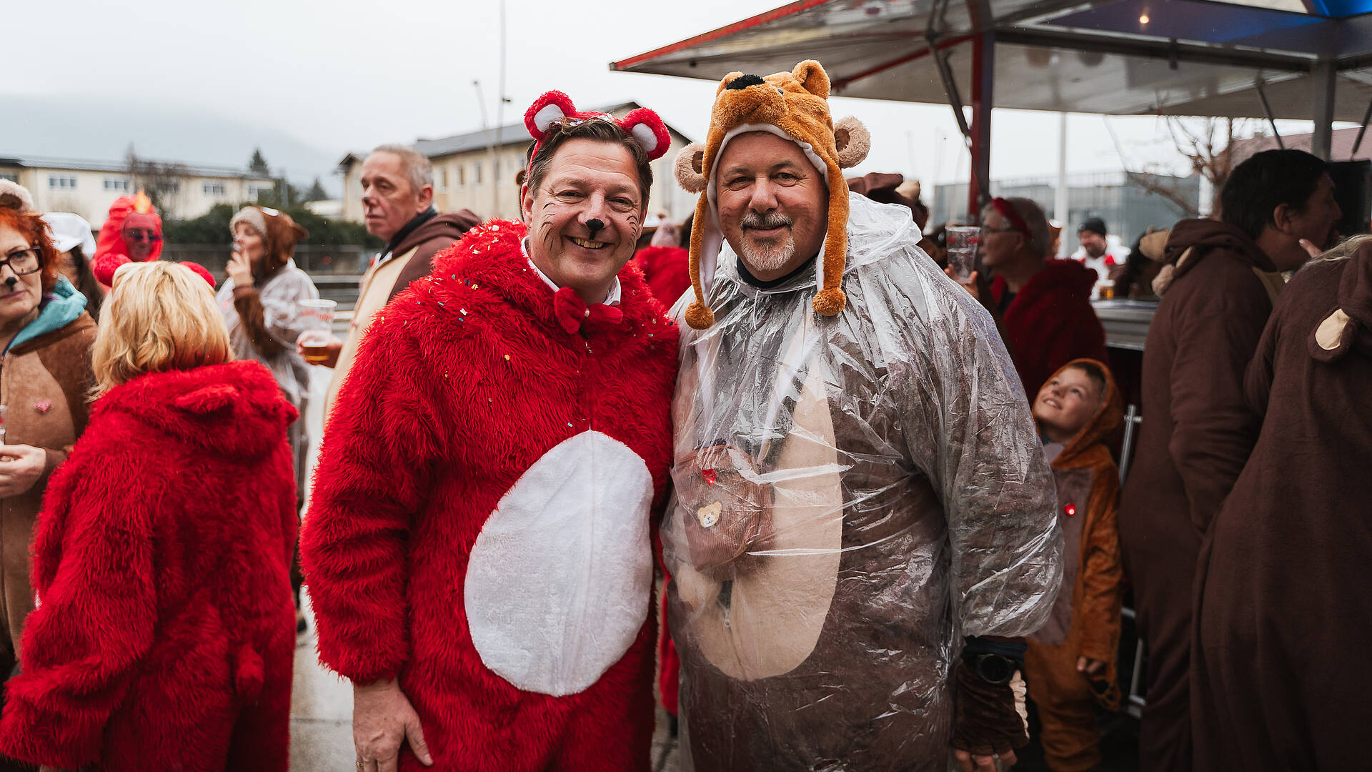 Bürgermeister Günther Albel steht in einem roten Tierkostüm beim Villacher Fasching neben einer weiteren verkleideten Person in der Villacher Innenstadt.