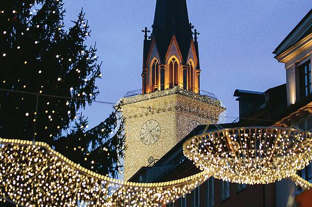 Advent in Villach mit beleuchtetem Kirchturm