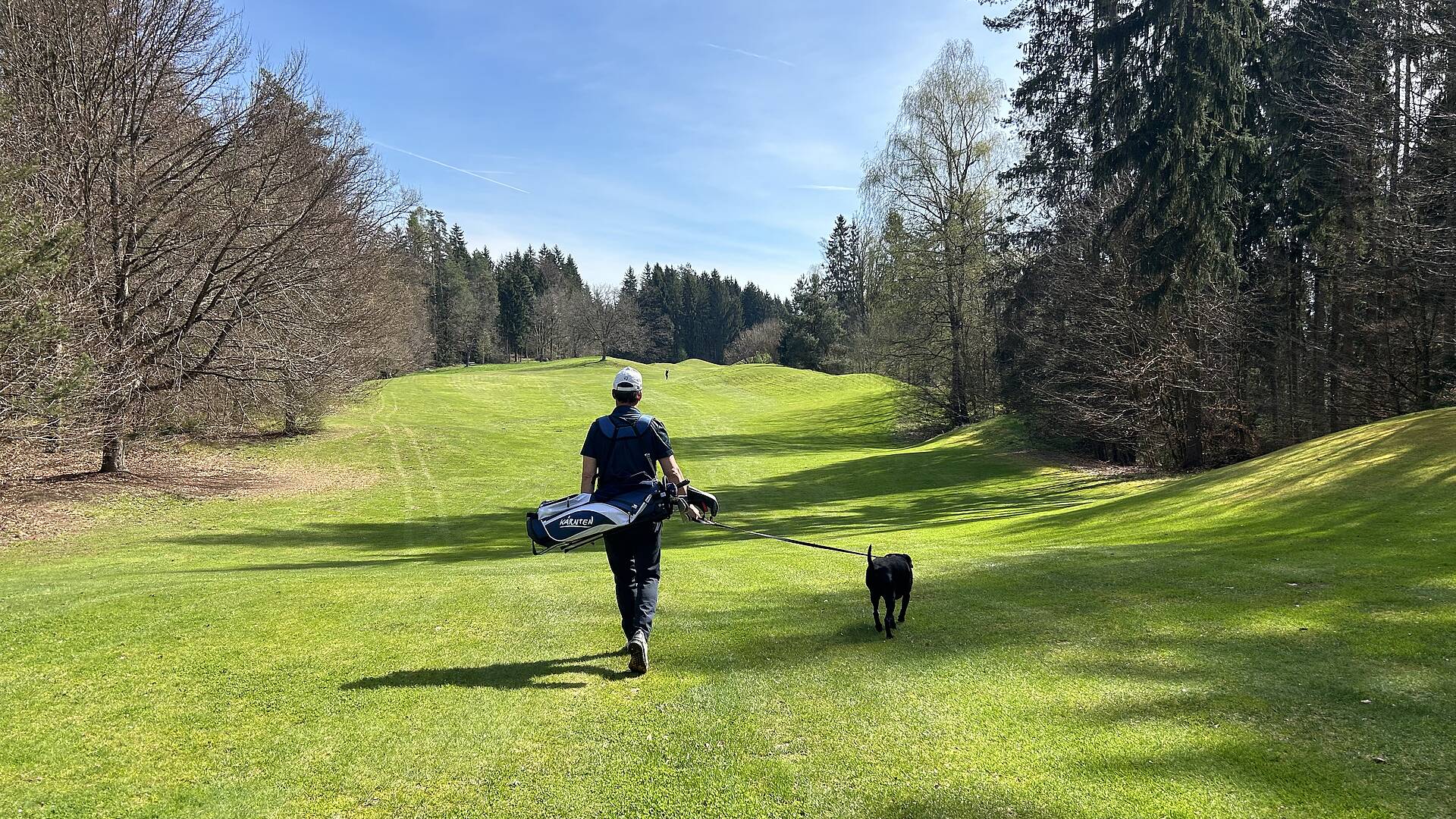 Golfspieler auf der Wiese mit Hund