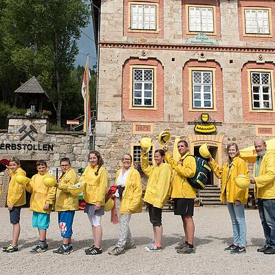 Gruppe in gelben Jacken vor dem Eingang zum Erbstollen in Knappenberg.