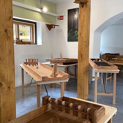 Holzspielraum mit mehreren Spieltischen im Holtarium – ein Spielpark für alle Altersgruppen in Kärnten.