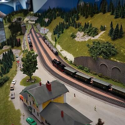 Modelleisenbahn-Anlage in der Erlebniswelt Eisenbahn in Spittal mit detailreicher Landschaft und fahrenden Zügen.