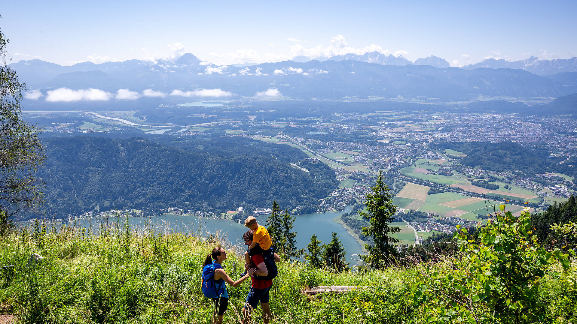Ein Paar wandert auf der Gerlitzen Alpe und genießt einen Blick auf den Ossiacher See.