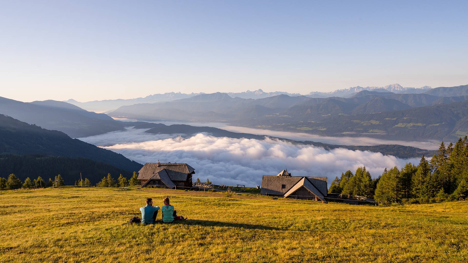 Paerchen beim Wandern auf der Millstaetter Alpe bei der Alexanderalm mit Blick auf den Millstaetter See