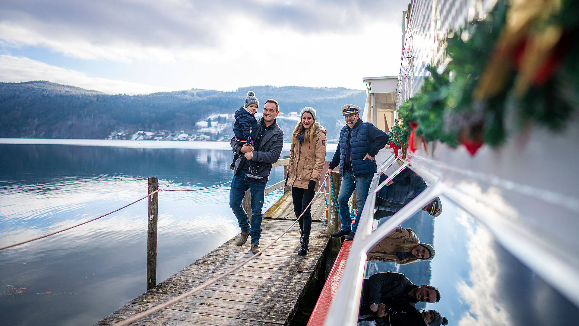 Advent am Millstaetter See mit Familie am Schiff