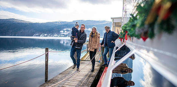 Advent am Millstaetter See mit Familie am Schiff
