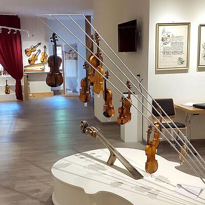 Innenraum des Geigenbaumuseums in Liesing mit zahlreichen Geigen, Ausstellungsstücken und einem Geigenrondell im Vordergrund