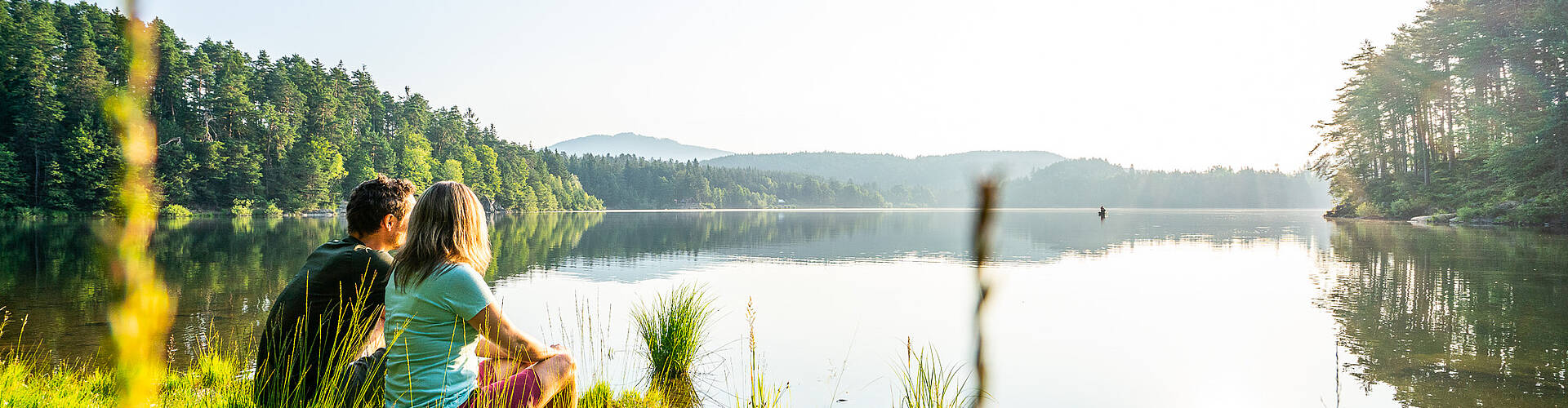 Eine Frau und ein Mann machen eine Pause beim Spaziergang auf dem Wörthersee-Rundwanderweg in der Römerschlucht bei Velden.