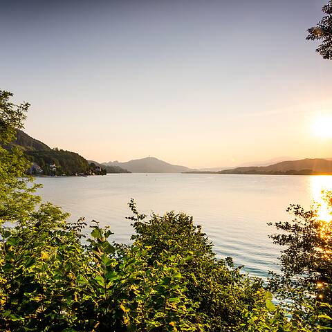 Sonnenuntergang ueber dem Woerthersee mit Pyramidenkogel im Hintergrund