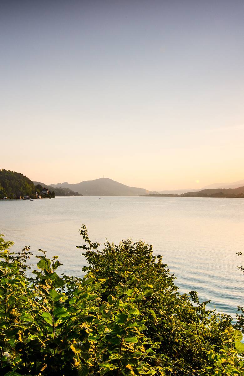 Sonnenuntergang ueber dem Woerthersee mit Pyramidenkogel im Hintergrund