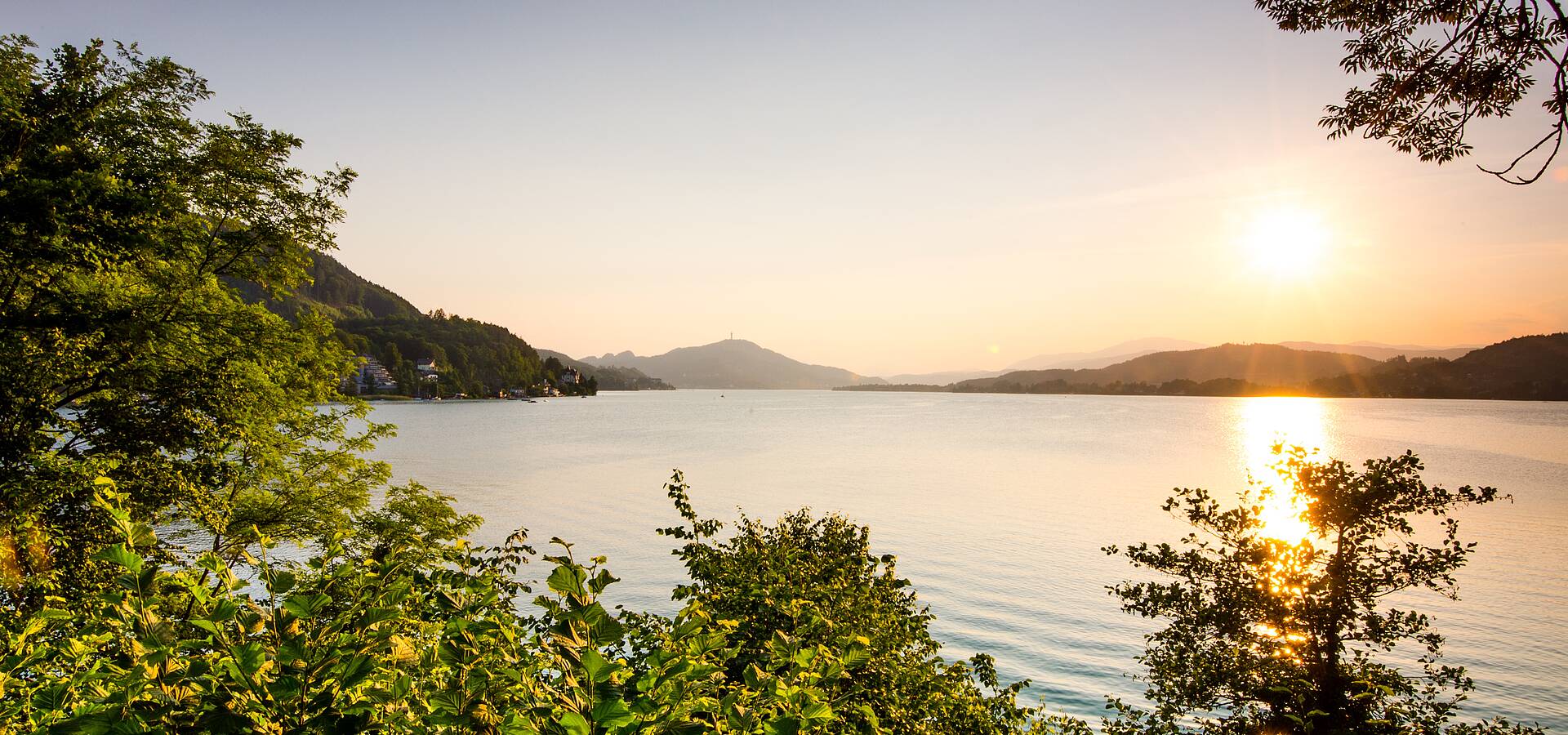 Sonnenuntergang ueber dem Woerthersee mit Pyramidenkogel im Hintergrund
