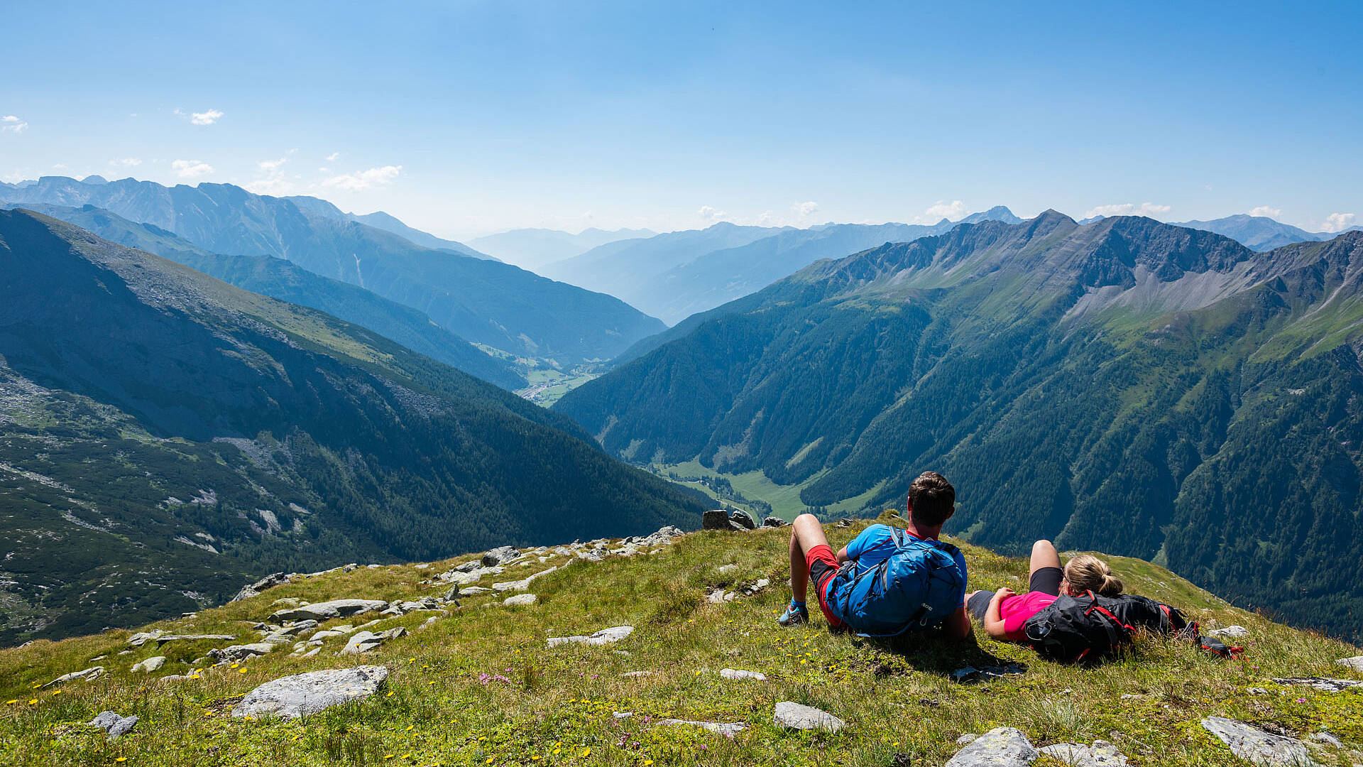 Pärchen beim Rasten am Tauernhöhenweg mit Blick ins Tal