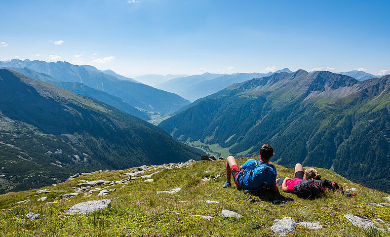 Pärchen beim Rasten am Tauernhöhenweg mit Blick ins Tal