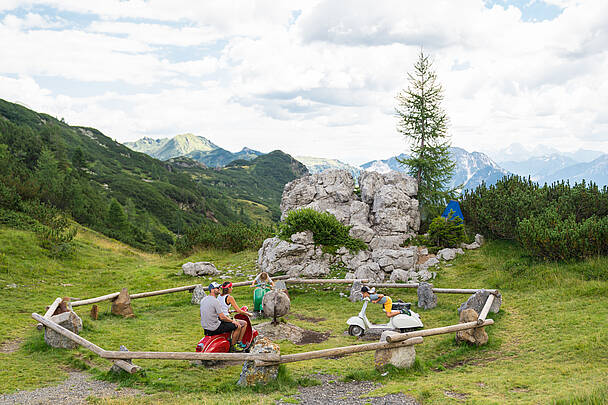 Ein Papa, eine Mama und ihre zwei Kinder machen eine Pause während ihrer Familienwanderung in der Region Nassfeld-Pressegger See