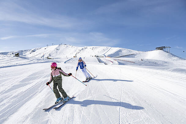 Mama mit Tochter beim Skifahren auf der Turracher Hoehe in den Nockbergen
