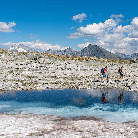 Pärchen beim Wandern am Tauernhöhenweg entlang eines Bergsees
