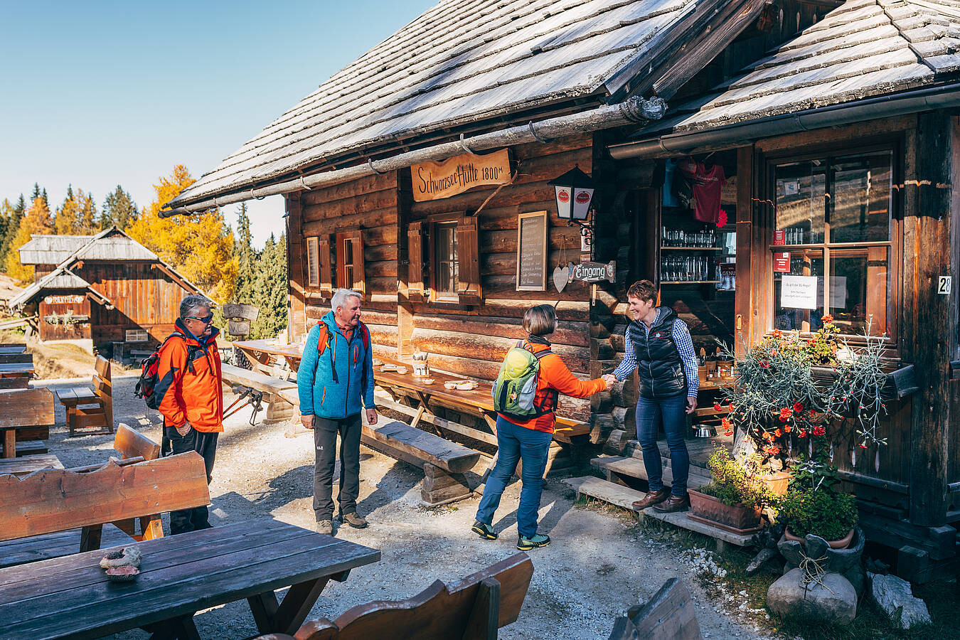 Drei Wandernde werden vor der Schwarzseehütte auf dem Verditz von der Hüttenwirtin begrüßt.