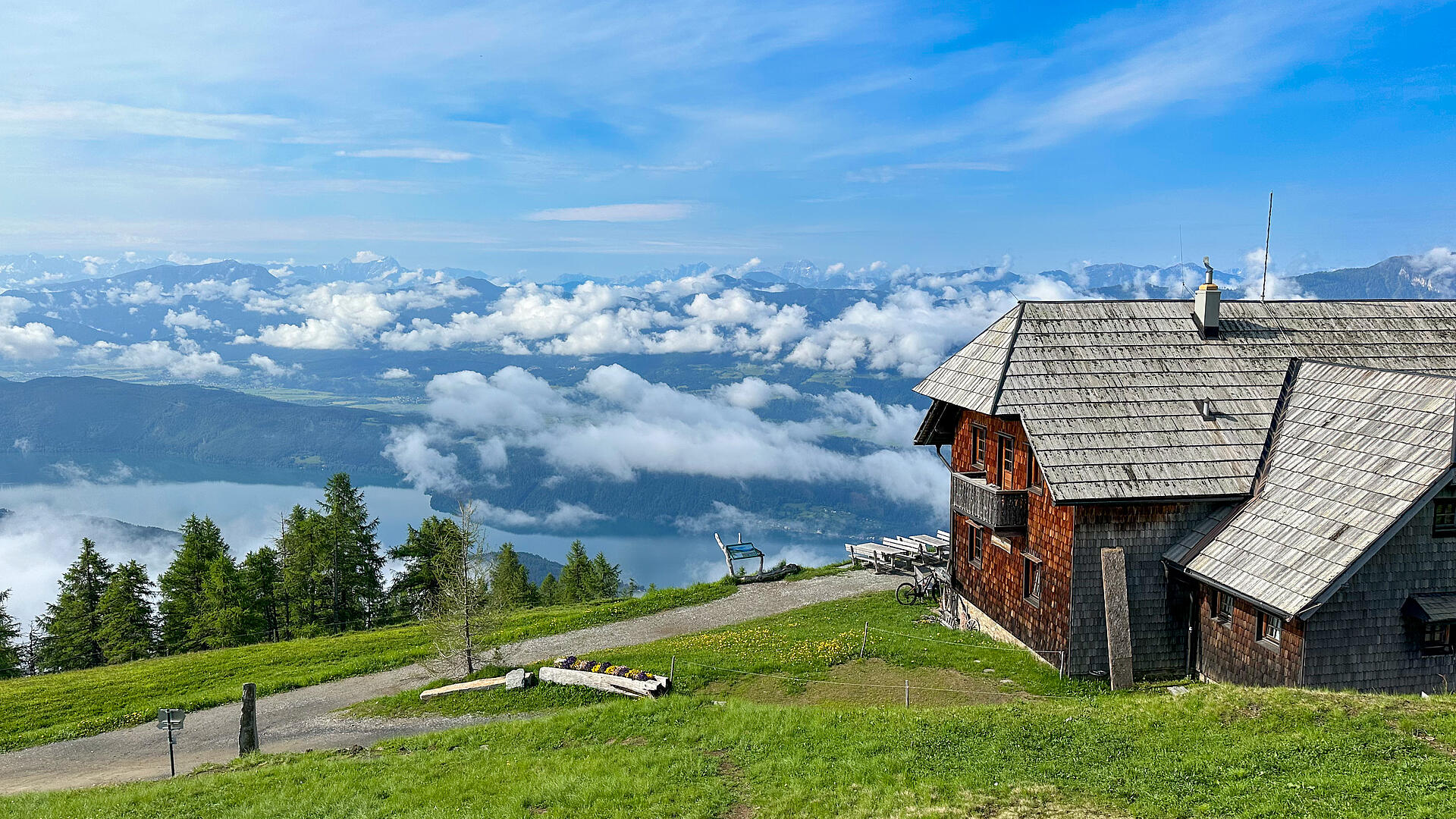 Die Alexanderhütte am Millstätter See ist von grünen Wiesen umgeben.