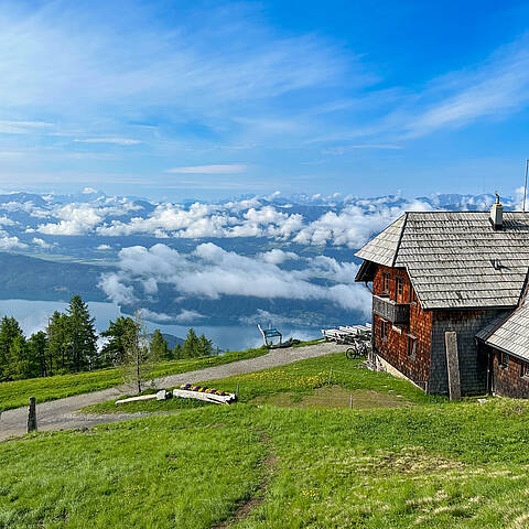 Die Alexanderhütte am Millstätter See ist von grünen Wiesen umgeben.