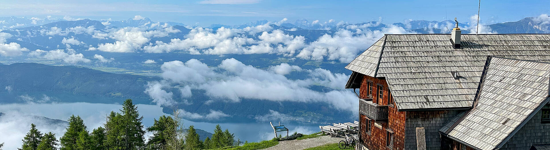 Die Alexanderhütte am Millstätter See ist von grünen Wiesen umgeben.