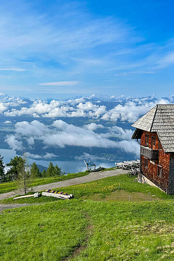 Die Alexanderhütte am Millstätter See ist von grünen Wiesen umgeben.