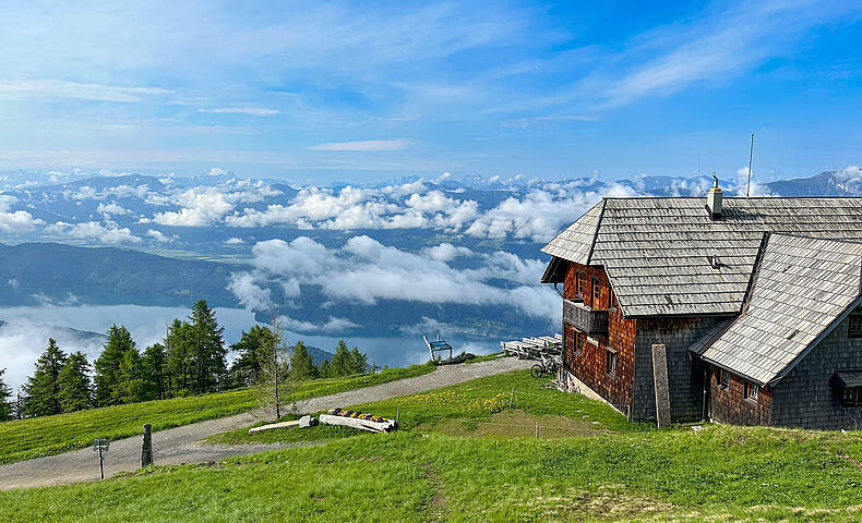 Die Alexanderhütte am Millstätter See ist von grünen Wiesen umgeben.