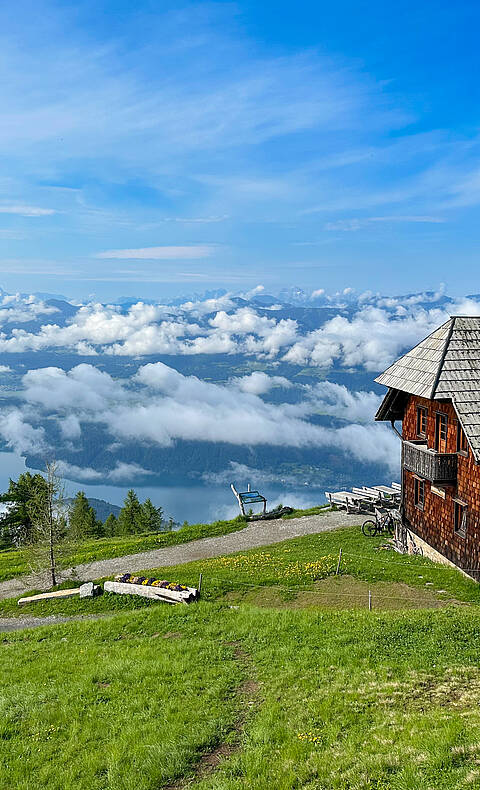 Die Alexanderhütte am Millstätter See ist von grünen Wiesen umgeben.