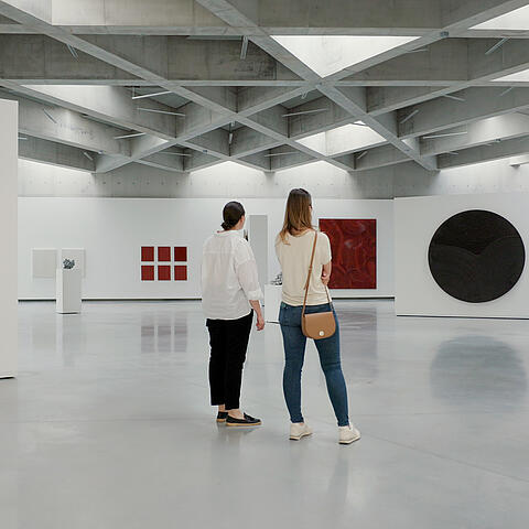 Frauen beim Betrachten der Bilder der Ausstellung im Museum Liaunig