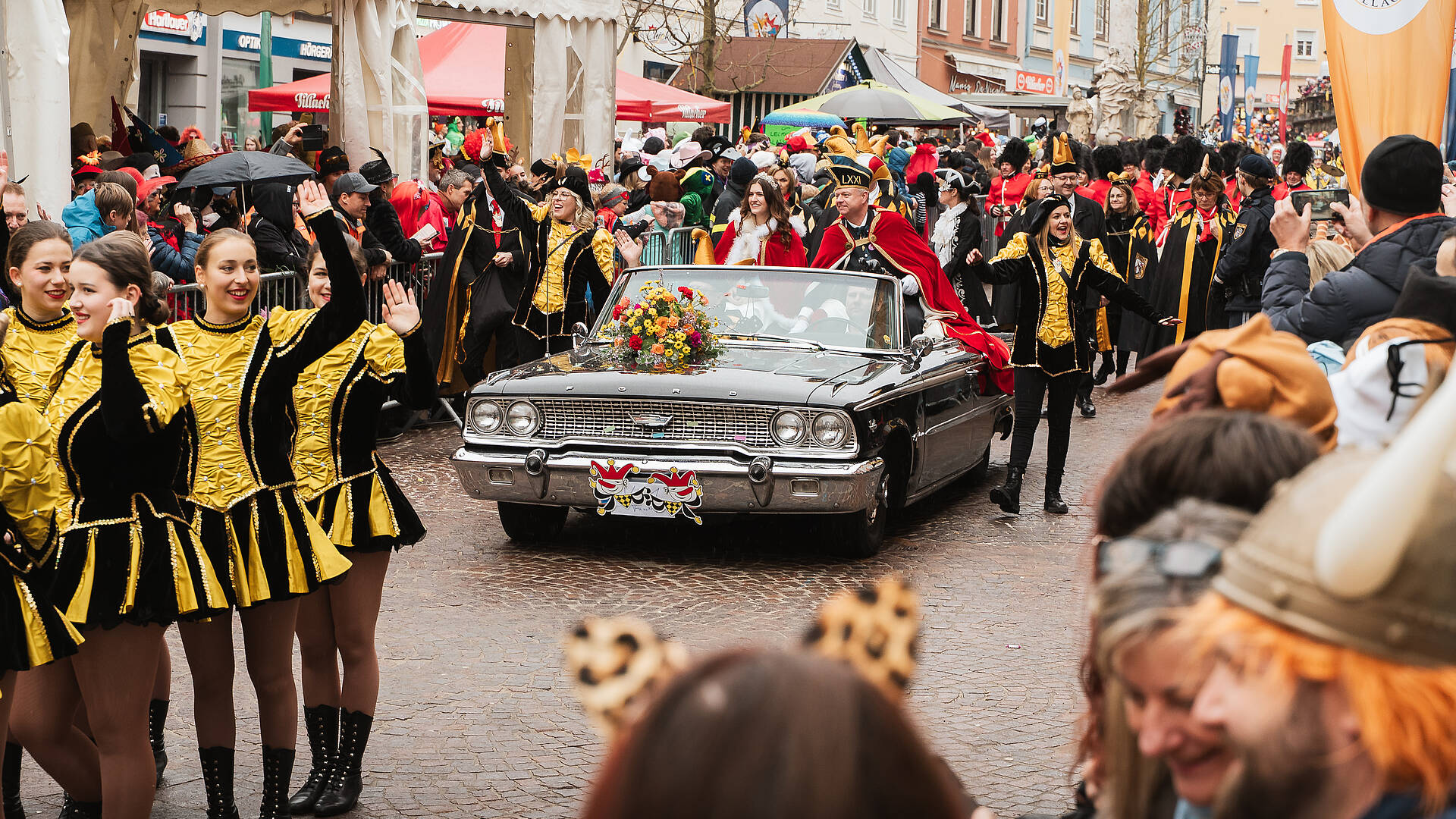 Oldtimer mit Blumenschmuck und kostümierte Gruppen beim Villacher Faschingsumzug in der Innenstadt.