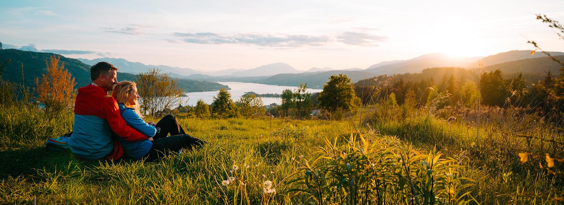 Eine Frau und ein Mann sitzen und machen eine Pause beim Wandern auf dem Wowrthersee-Rundwanderweg am Pirkerkogel.