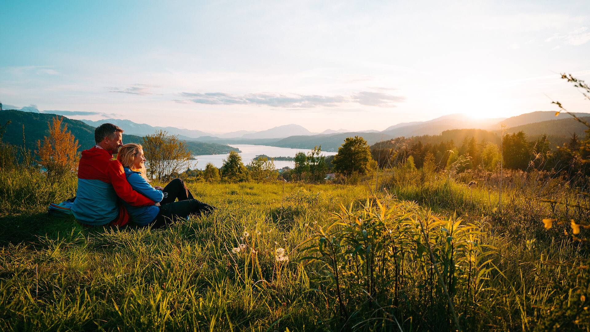 Eine Frau und ein Mann sitzen und machen eine Pause beim Wandern auf dem Wowrthersee-Rundwanderweg am Pirkerkogel.