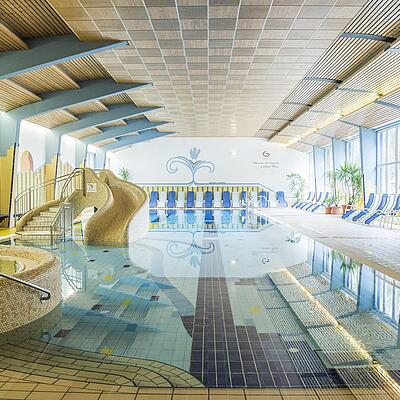 Innenbereich des Tauernbads Mallnitz mit Whirlpool, Wasserrutsche und Schwimmbecken..