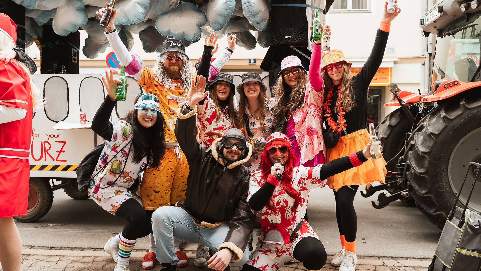 Gruppe verkleideter Personen vor einem Faschingswagen beim Villacher Fasching in Villach.