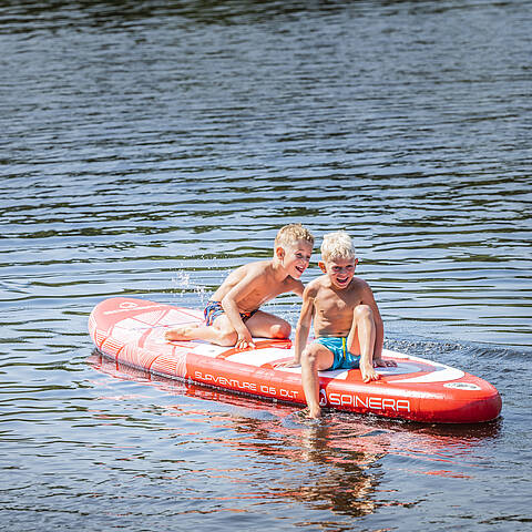 Familie beim Baden und Stand up paddlen im Flatschacher See