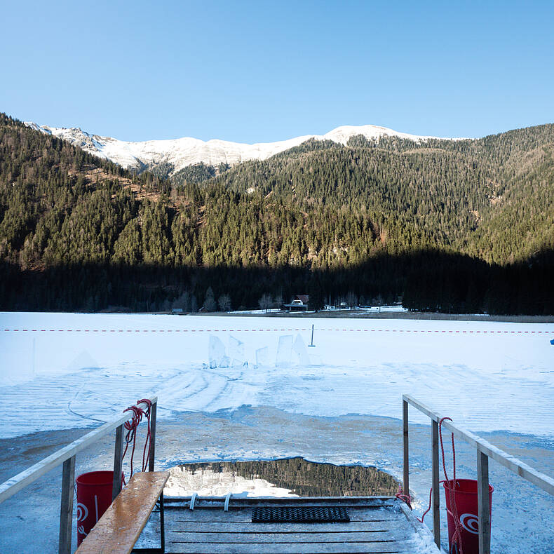 Steg mit Blick auf den zugefrorenen Weissensee