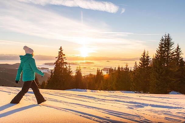 Frau im grünen Anorak beim Winterwandern auf der Saualpe