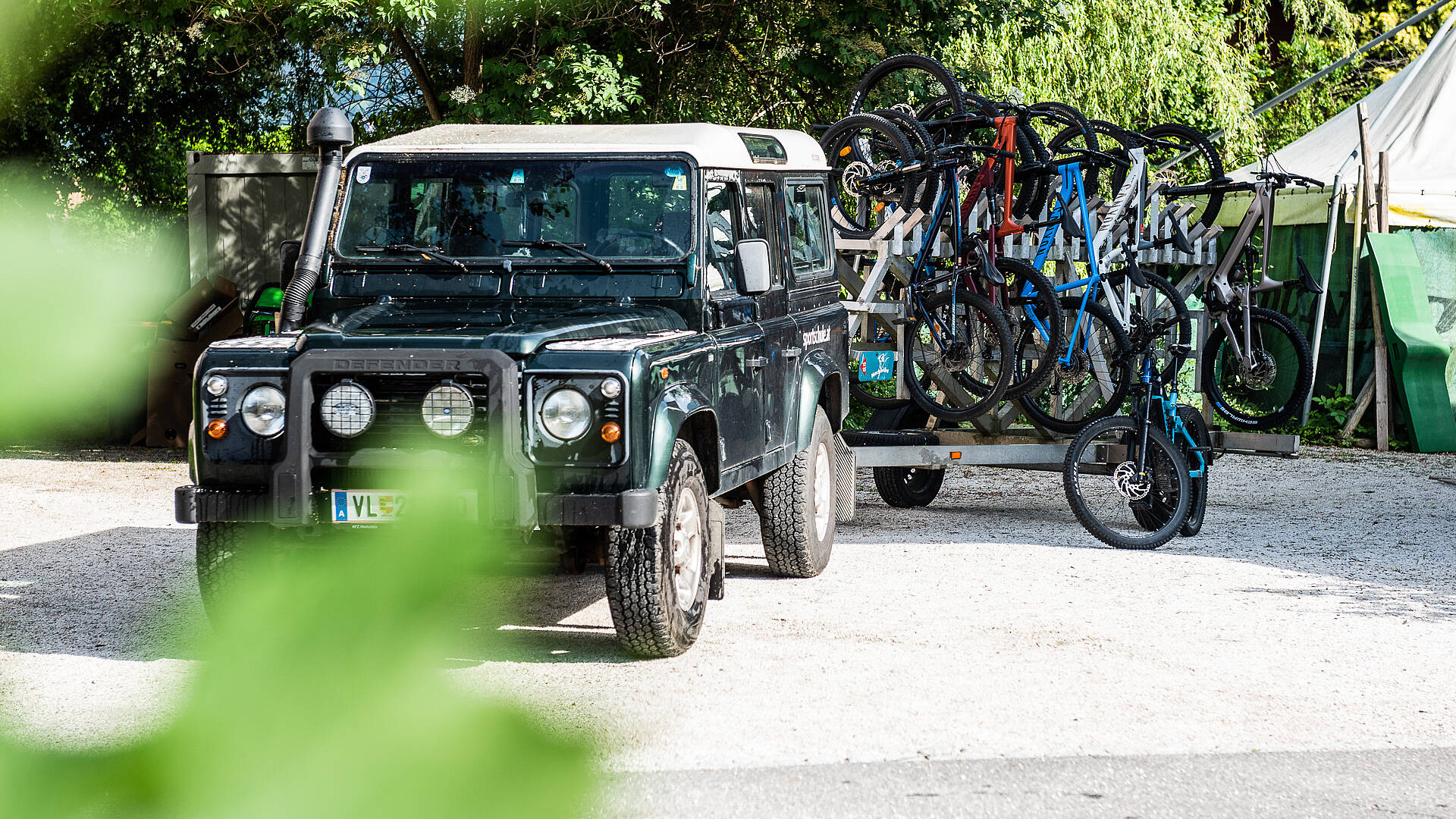 Mit dem Auto und einem Anhänger die Bikes transportieren.