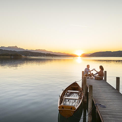 Paerchen am Steg im Herbst am Woerthersee in Poertschach
