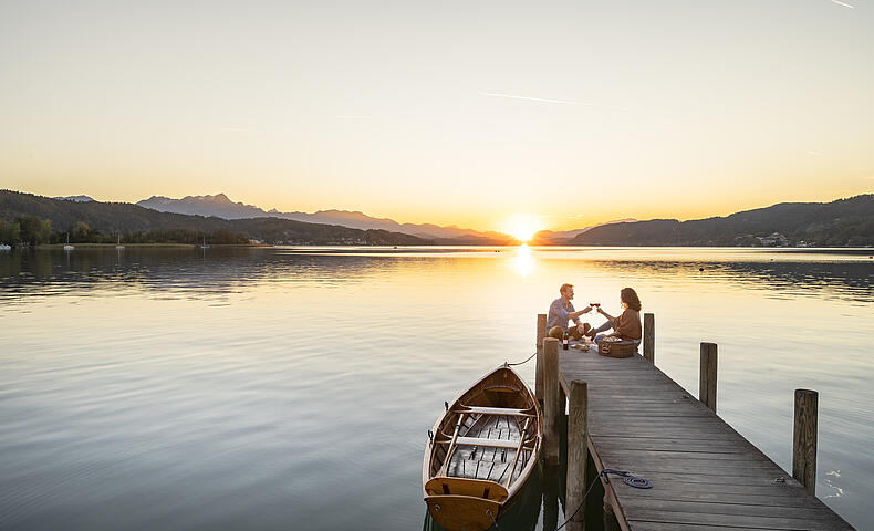 Paerchen am Steg im Herbst am Woerthersee in Poertschach