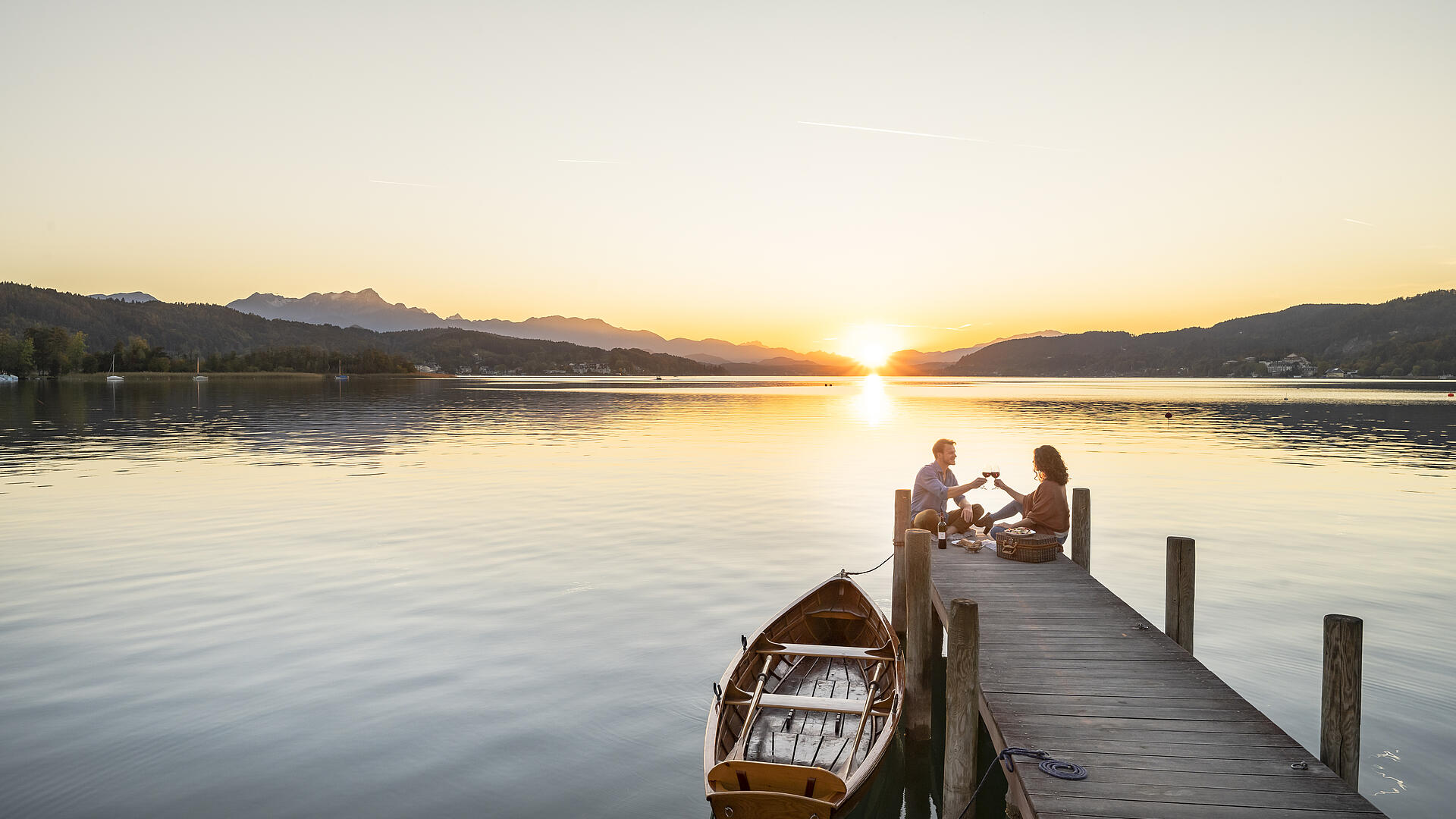 Paerchen am Steg im Herbst am Woerthersee in Poertschach