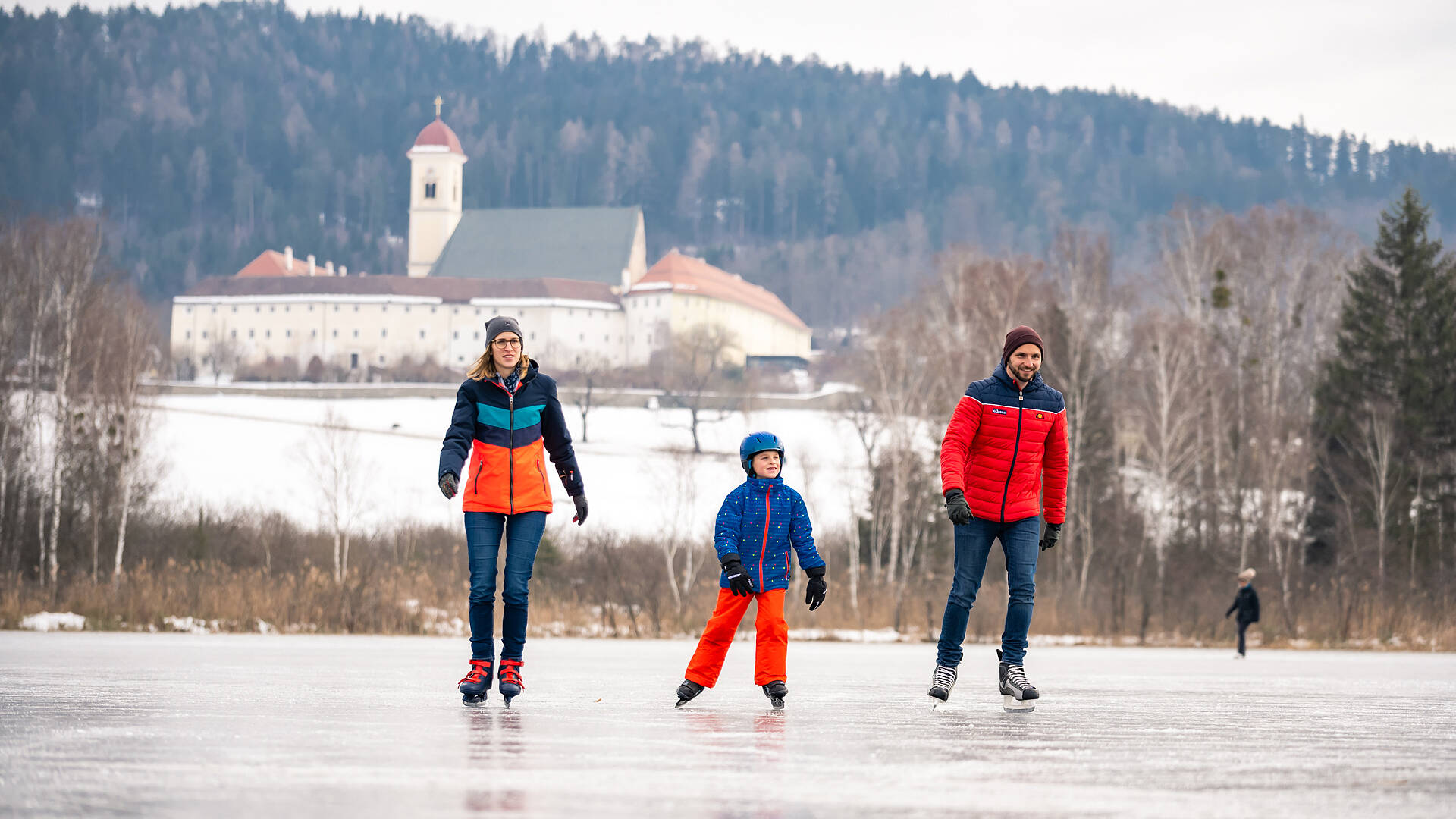 Familie beim Eislaufen am Laengsee in St. Georgen