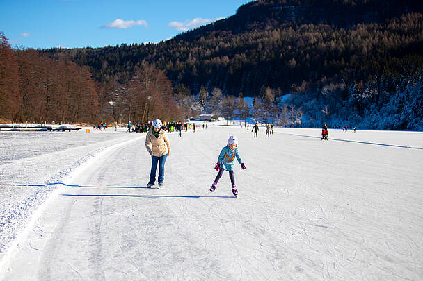 Familie beim Eislaufen am Rauschelesee im Keutschacher Seental