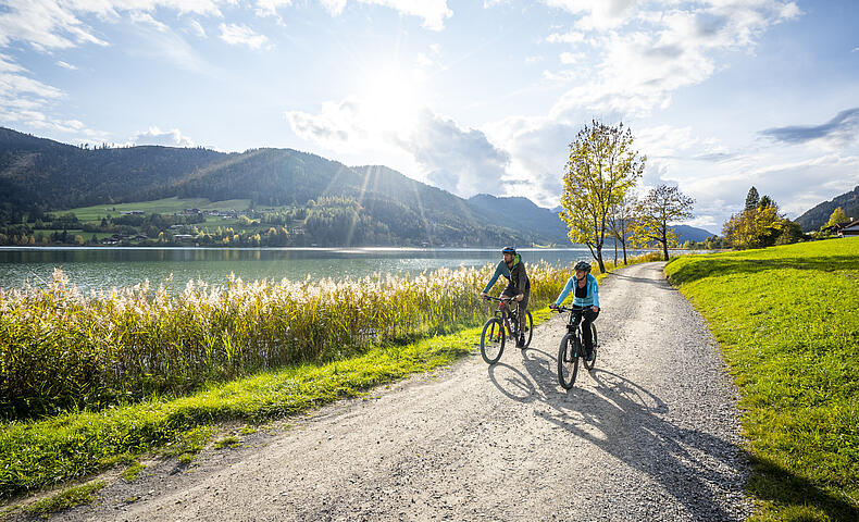 Frau und Mann beim Radfahren im Herbst am schönen Weissensee