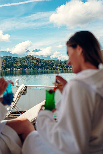 Zwei Frauen genießen ein Getränk im Hotel Amerika Holzer am Klopeiner See