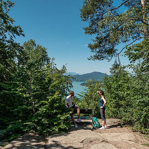 Mann und Frau machen eine Pause bei der Wanderung am Kreuzbergl in Klagenfurt am Wörtheree