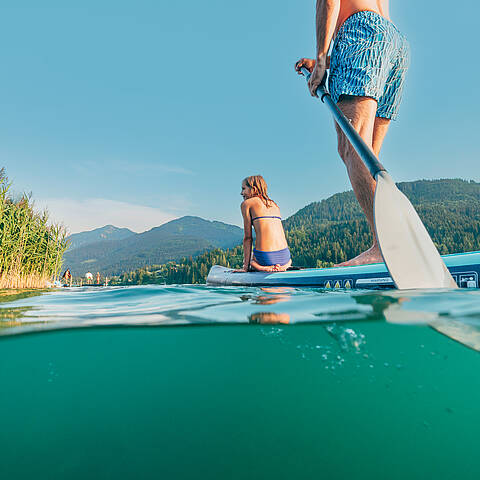 Vater und Tochter beim Stand-up-Paddling am Weissensee