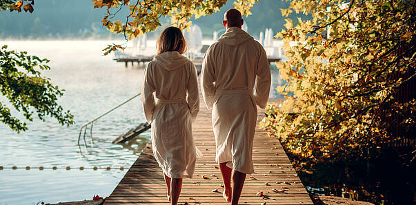 Eine Frau und ein Mann machen einen kurzen Spaziergang nach dem Seenwellness im Herbst