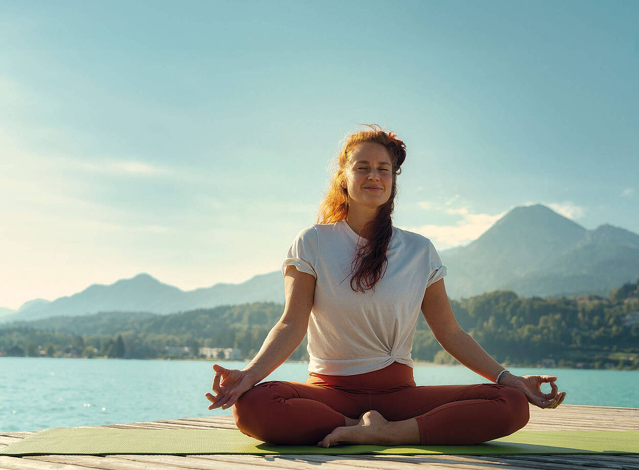 Frau macht Yogaübungen am Faaker See 